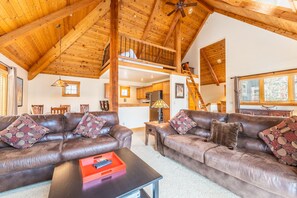 The living area offers cozy furnishings, vaulted ceilings, and a gas fireplace.