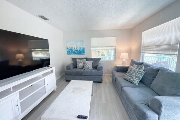 Spacious living room with an natural light streaming in through the large windows