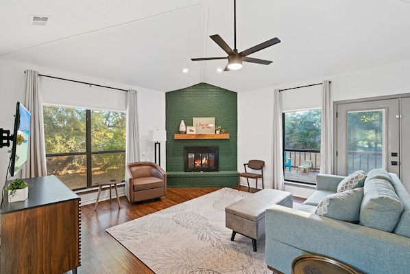 Main living room looks out to secluded property with iconic art and a Smart TV.