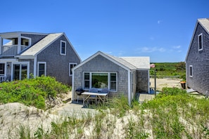 Back of the home with seating and a grill.