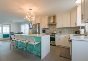 Large updated kitchen with an island and seating for four guests.