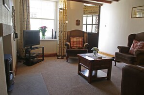 Cosy lounge with woodburning stove at Jesmond Cottage in West Burton, Wensleydale in the Yorkshire Dales