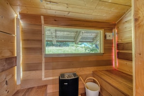 Le sauna deux places sur la terrasse et avec une vue extérieur sur les prés.