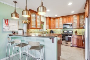 This contemporary, fully equipped kitchen features a bar with casual seating, high-end appliances, and premium cookware.