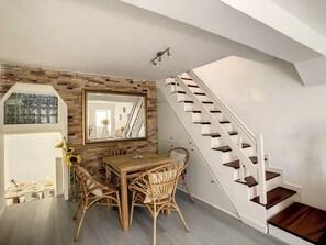 Shifting our focus to the dining area, this photo also offers a glimpse of the elegant staircase leading to the upper floor.