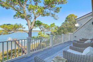Private deck overlooking serene waters and surrounded by lush trees, ideal for morning coffee or sunset views.