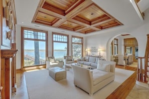 Spacious living room with stunning river views and natural light, perfect for relaxation and gatherings.