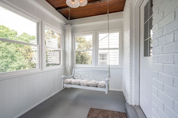 The sunroom porch swing is the perfect spot for relaxing with a book