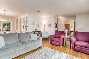 Gather in the cozy and inviting living room, boasting a plush sofa and two comfortable arm chairs for ultimate relaxation.