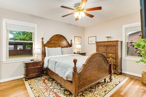The primary bedroom features a comfortable queen-sized bed with plush bedding, ensuring a restful night's sleep.