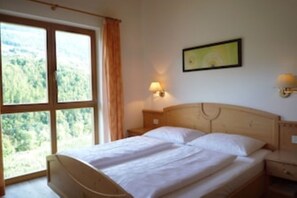 Doppelzimmer mit großem Fenster und Blick ins Gebirge