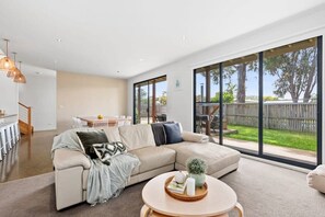 The downstairs living area is the heart of the home, featuring a cosy chaise lounge where you can settle in for a movie night