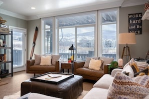 The living room, freshly appointed with comfortable furniture, offers easy access to the outdoor balcony.