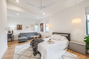 Spcaious primary bedroom with vaulted celing and seating area. 