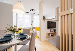 A dining area with a wooden table, blue plates, and contemporary decor, connected to the living space for an open-plan feel.
