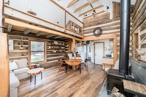 Unique rustic cabin with open layout and wood stove.