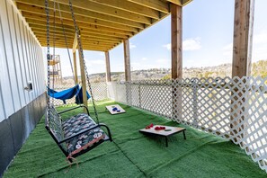 Fenced yard with yard games, hammocks, and patio swing