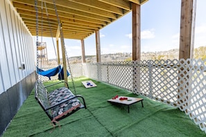 Fenced yard with yard games, hammocks, and patio swing