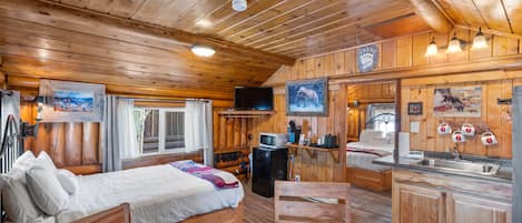 Front room of cabin. Dining Area, Queen Bed, TV, Microwave Minifridge, Coffee & Tea, Sink