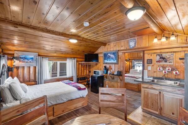 Front room of cabin. Dining Area, Queen Bed, TV, Microwave Minifridge, Coffee & Tea, Sink