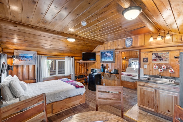 Front room of cabin. Dining Area, Queen Bed, TV, Microwave, Minifridge, Coffee and Tea