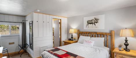 View of room from doorway. Queen Bed, Entrance to bathroom.