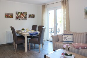Wohnbereich mit Esstisch, Sofa und Zugang zur Terrasse