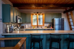 Well stocked kitchen with breakfast bar (seating for 4)