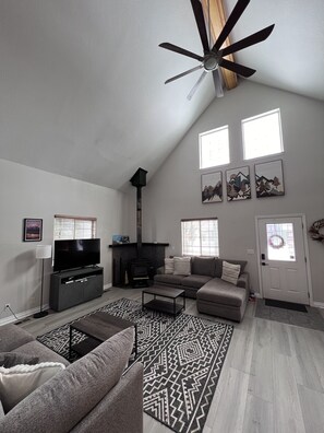 Large windows with lots of natural light, including a wood burning fireplace.