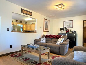 Spacious living room has two reclining sofas. Large smart Roku TV, piano & Desk.