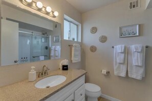 The master bathroom includes a walk in shower, soaps, shampoo, conditioner.