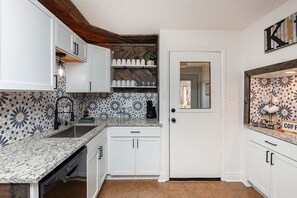 Fully stocked kitchen with most everything you could need. Leads to back deck