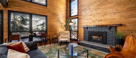 Experience the cozy living room, outfitted with plush seating, a fireplace, and windows that frame the breathtaking mountain vistas.