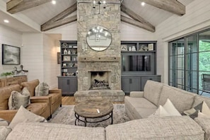 Stone fireplace with gas logs, exposed beams, custom leather recliners & more.