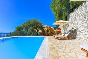 Sunlounges and umbrellas around the sunny terrace