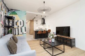 A well-lit open-plan living space with modern furnishings and an artistic touch in the decor.
