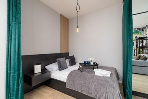 A cozy bedroom featuring a comfortable bed, green curtains, and minimalist design elements.
