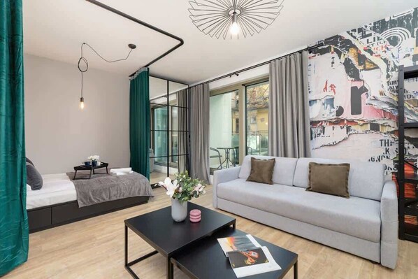 A stylish living room with a large sofa, modern decor, and floor-to-ceiling windows for plenty of natural light.

