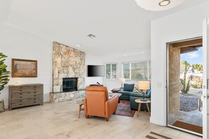 Living room with leather recliner and smart TV.