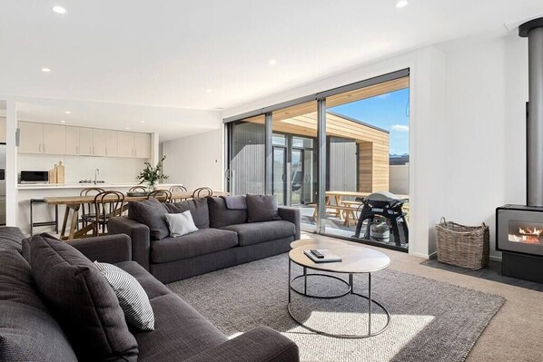 Living room with plenty of firewood for chilly nights. BBQ with outdoor seating. 