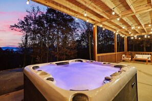 Enjoy the large, well maintained hot tub under the string lights at sunset