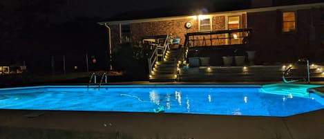 night view with pool on back of house 