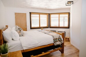 Daisy Mae room with king bed, rustic wood finishes, and en-suite half bath.