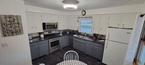 Well stocked kitchen, picnic basket is on top of the fridge for you to use.