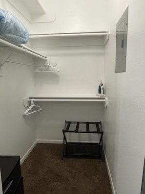 Walking closet, luggage rack, mini ironing board and Black+Decker  iron. 
