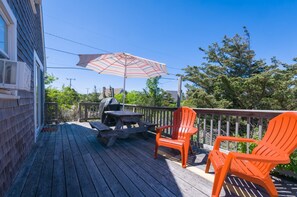 Deck with seating and a grill available to guests.