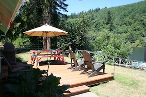 Deck with Adirondack Chairs, Picnic Table and Weber Gas Grill, faces the river