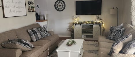 Living Room with 2 new couches, coffee table, and smart TV. 