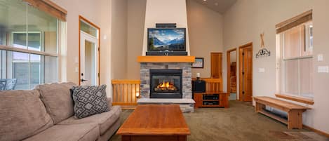 Living area with a large sectional sofa,  flat screen TV and gas fireplace. There are plenty of windows to enjoy the amazing views!