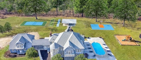 [Resort Property] Aerial View of property with heated pool, pickleball court, basketball, shuffleboard, bocce, playground and more!